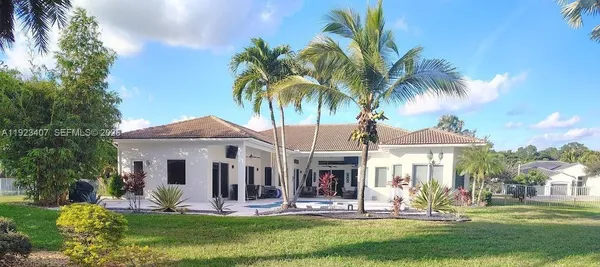 a front view of a house with garden and sitting area