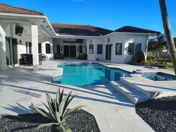 a front view of a house with swimming pool patio and outdoor seating