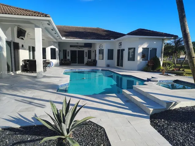 a front view of a house with swimming pool patio and outdoor seating