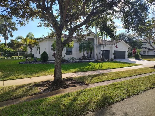a view of a house with garden and trees