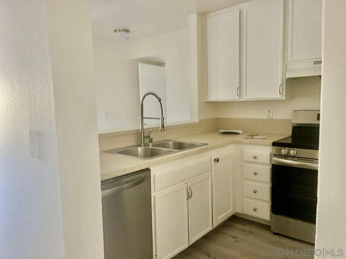 3980 Faircross Place, Unit 23 San Diego, CA 92115 - Photo 2 of 21 a kitchen with white cabinets and white appliances