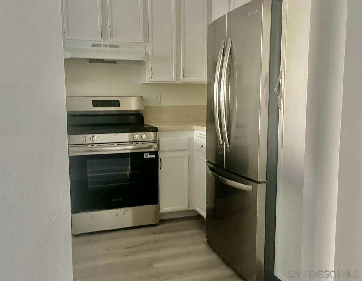 3980 Faircross Place, Unit 23 San Diego, CA 92115 - Photo 4 of 21 a kitchen with cabinets and stainless steel appliances