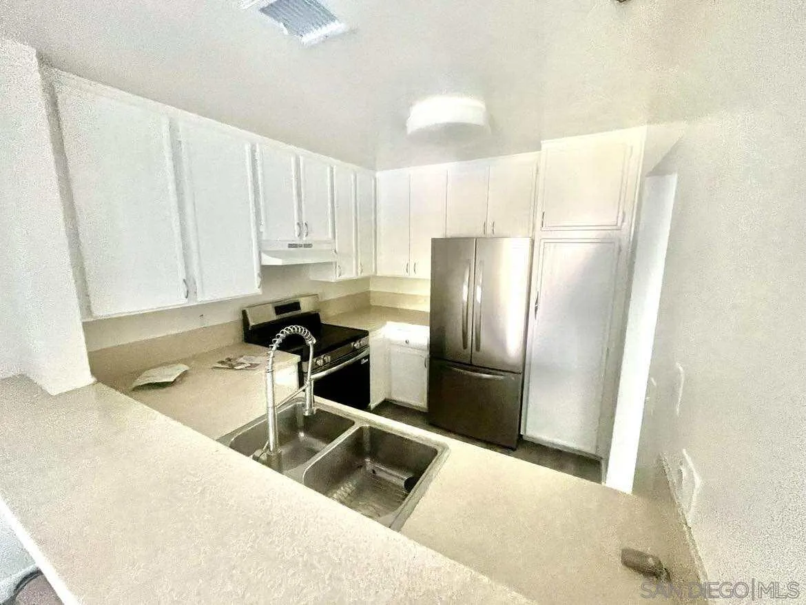 3980 Faircross Place, Unit 23 San Diego, CA 92115 - Photo 7 of 21 a kitchen with stainless steel appliances granite countertop a refrigerator a stove and a sink