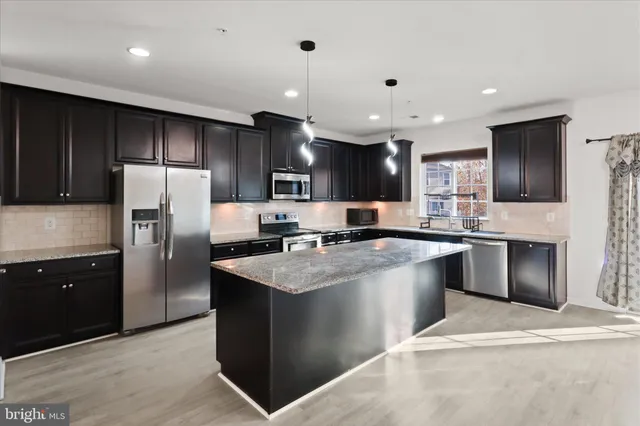 a large kitchen with stainless steel appliances lots of counter space cabinets and a sink