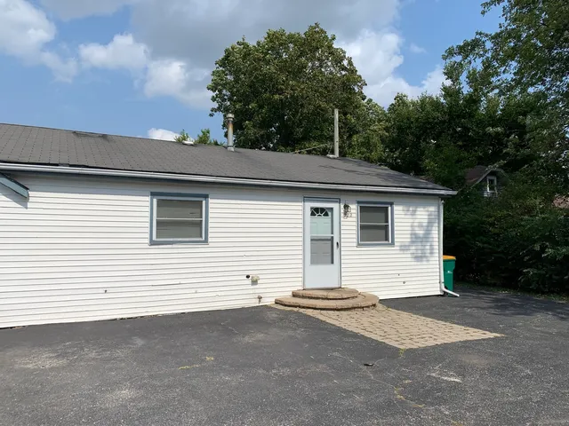 a view of a white house with a white fence
