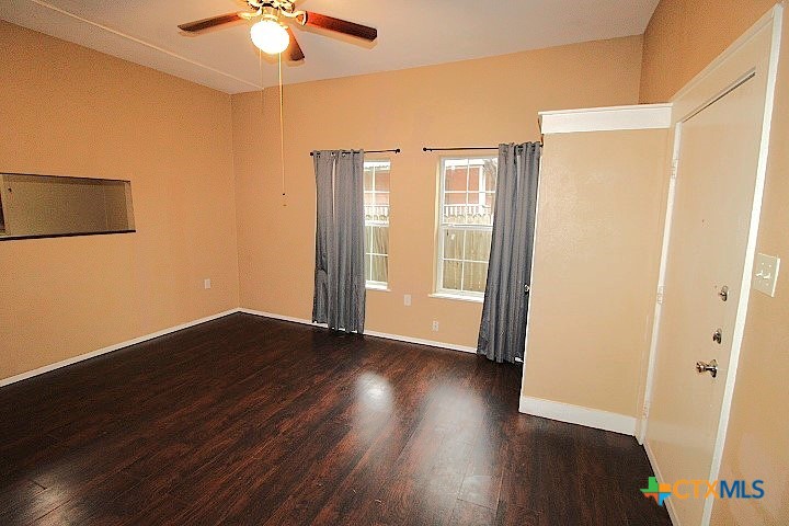 207 North 6th Street Temple, TX 76501 - Photo 2 of 5 a view of an empty room with wooden floor and a window