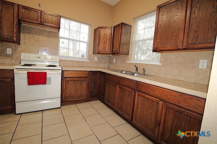 207 North 6th Street Temple, TX 76501 - Photo 4 of 5 a kitchen with stainless steel appliances granite countertop a sink stove and cabinets