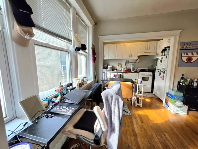 a view of a workspace with furniture and a window