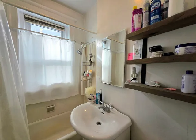 a bathroom with a sink a mirror and a window