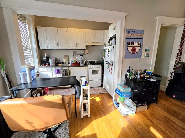 a living room with stainless steel appliances furniture fireplace and a table
