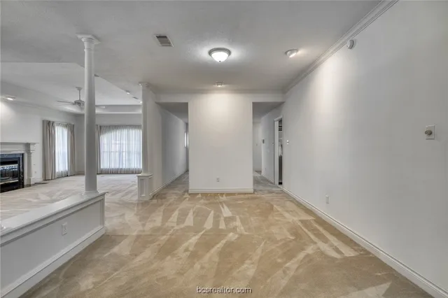 an empty room with a fireplace and fan