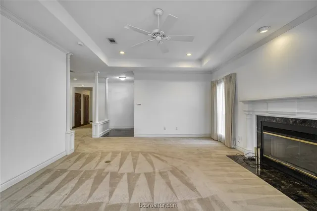 a view of an empty room with a fireplace and a window