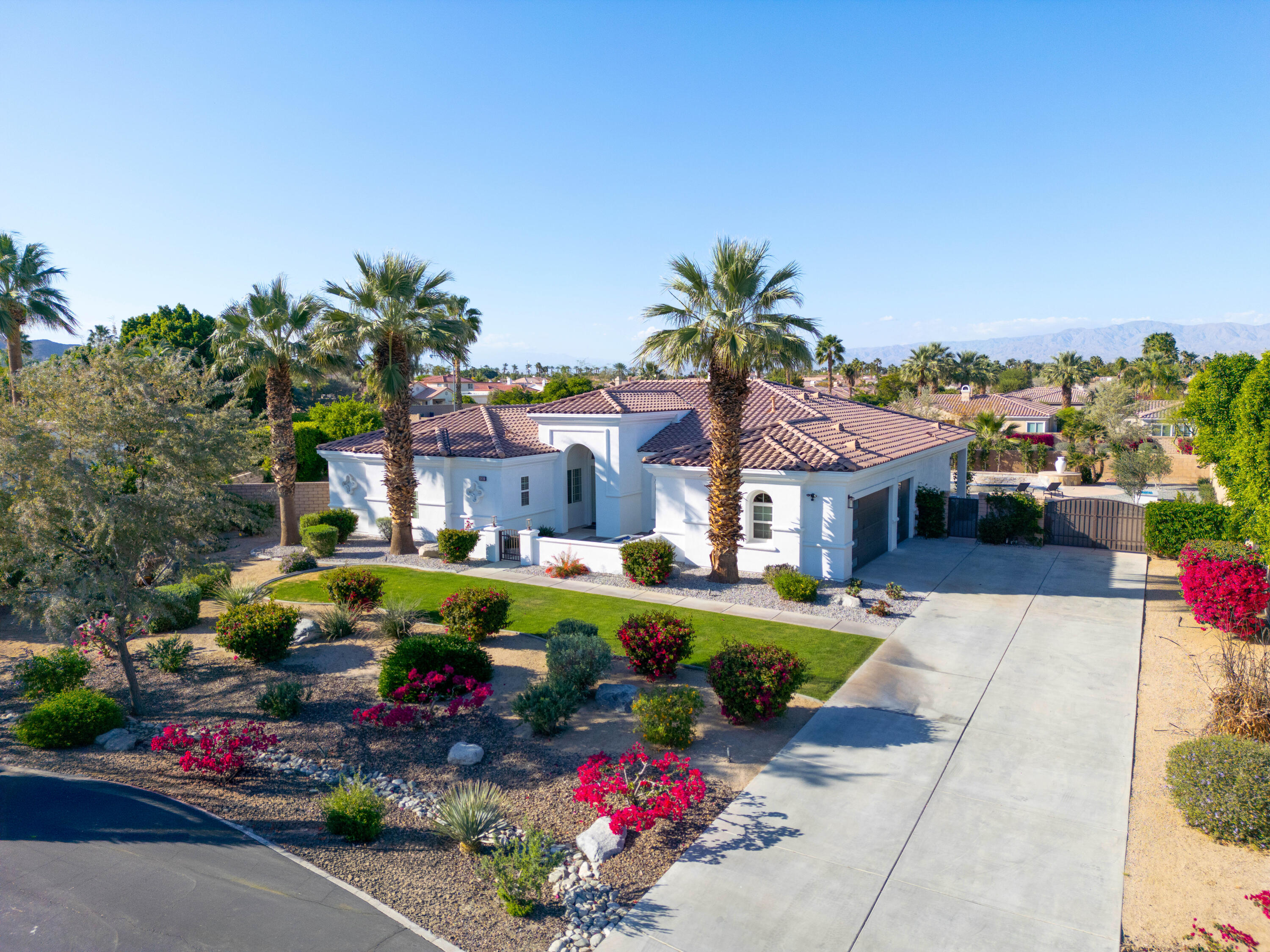 a front view of a house with a garden and mountain view