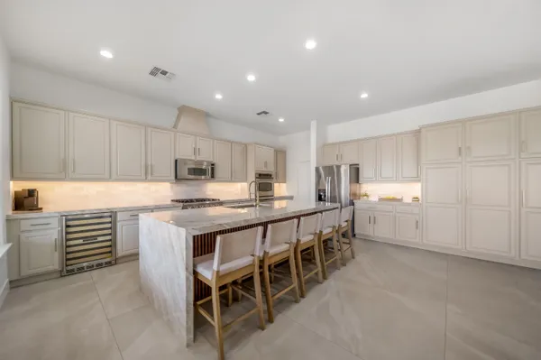 a kitchen with kitchen island a large counter top space appliances and cabinets