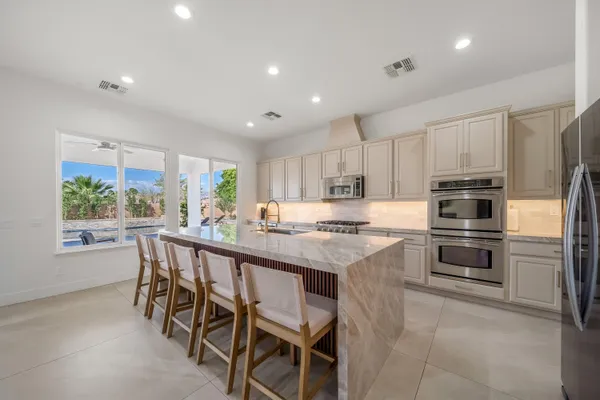 a kitchen with white cabinets and appliances