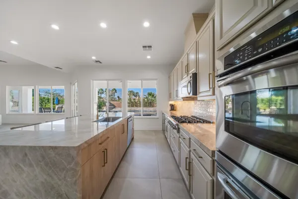 a living room with furniture kitchen view and a large window