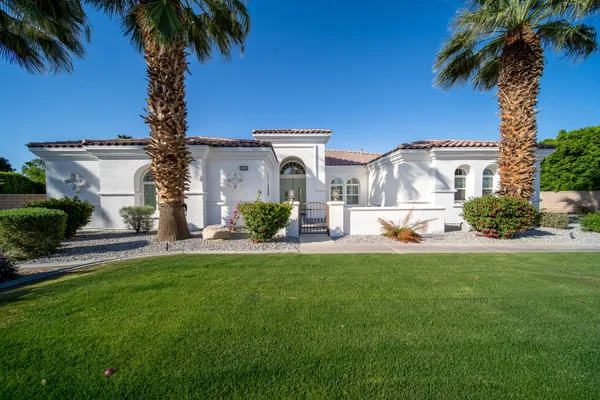a front view of a house with a garden and yard