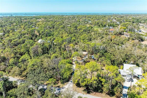 an aerial view of residential houses with outdoor space and trees