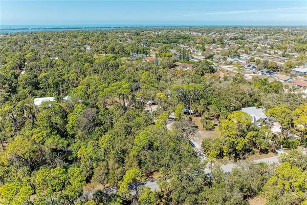an aerial view of residential houses with outdoor space and trees