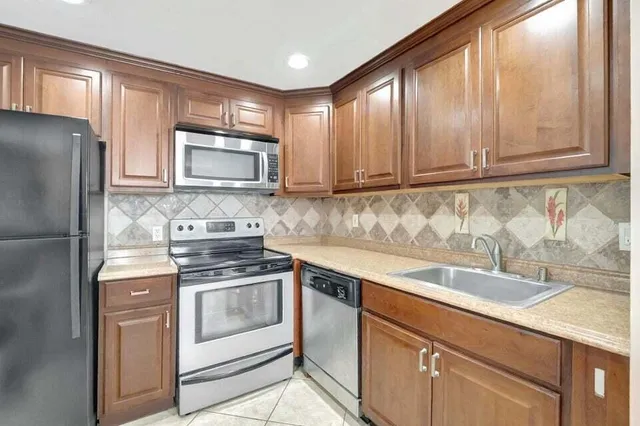 a kitchen with granite countertop cabinets stainless steel appliances and a sink