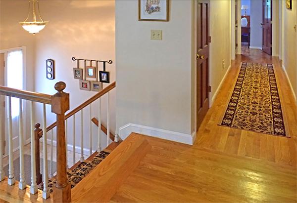 53 Squire Road Winchester, MA 01890 - Photo 4 of 11 a view of a hallway with wooden floor and staircase