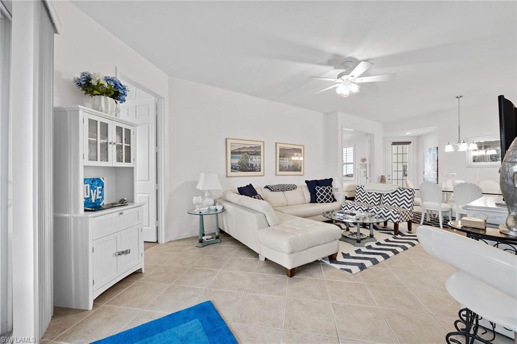 4685 Hawks Nest Way, Unit 103 Naples, FL 34114 - Photo 11 of 35 a living room with furniture and a chandelier