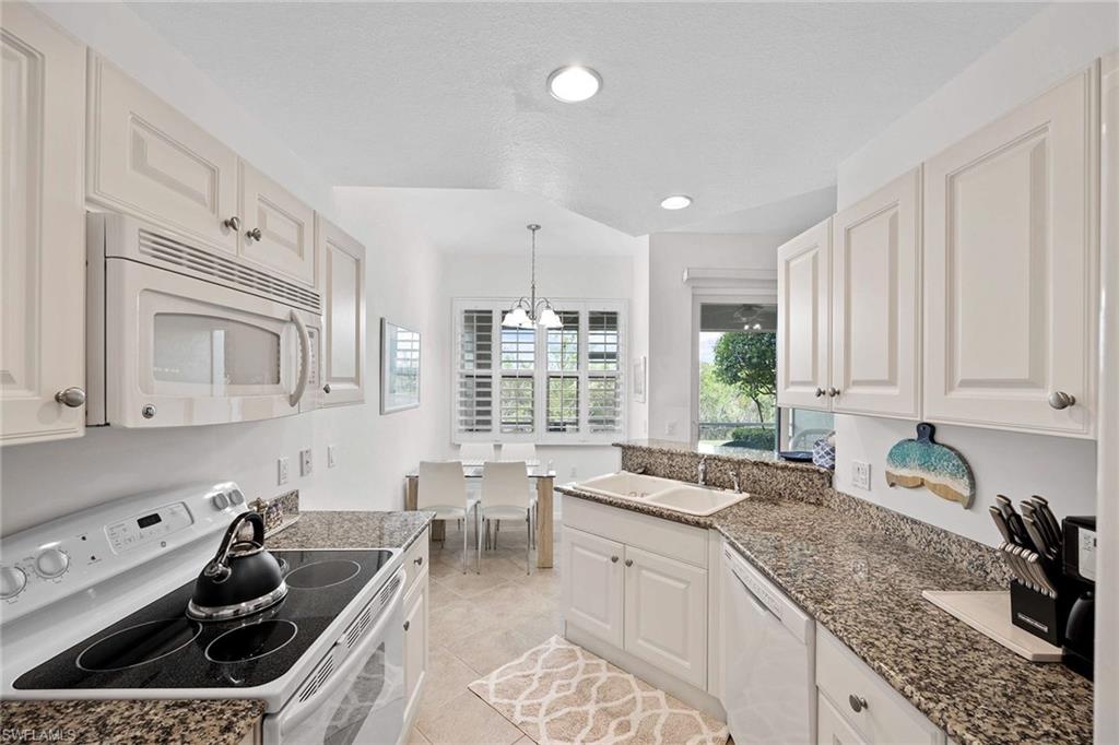 4685 Hawks Nest Way, Unit 103 Naples, FL 34114 - Photo 13 of 35 a kitchen that has a sink and a stove in it