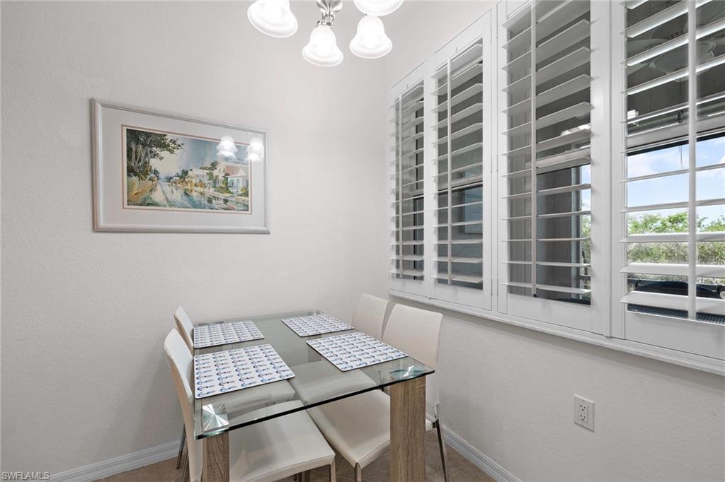 4685 Hawks Nest Way, Unit 103 Naples, FL 34114 - Photo 14 of 35 a view of a dining room with furniture and a large window