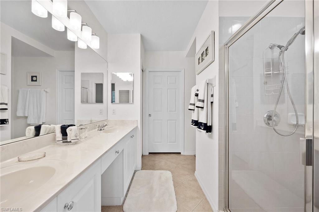 4685 Hawks Nest Way, Unit 103 Naples, FL 34114 - Photo 16 of 35 a spacious bathroom with a double vanity sink mirror and shower