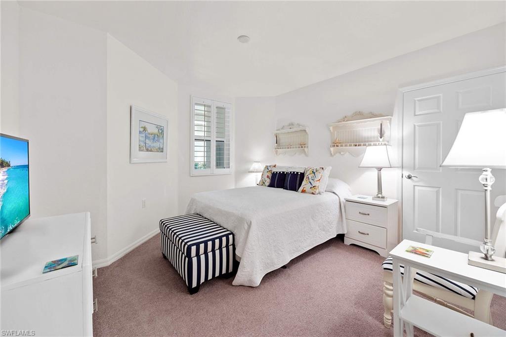 4685 Hawks Nest Way, Unit 103 Naples, FL 34114 - Photo 20 of 35 a spacious bedroom with a bed and a cabinets