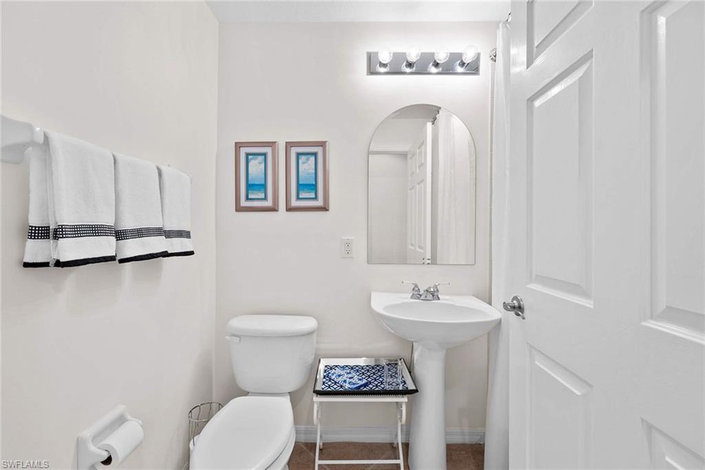 4685 Hawks Nest Way, Unit 103 Naples, FL 34114 - Photo 21 of 35 a bathroom with a toilet sink and mirror