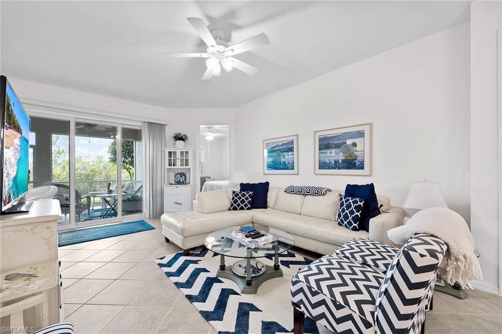 4685 Hawks Nest Way, Unit 103 Naples, FL 34114 - Photo 9 of 35 a living room with furniture and a large window