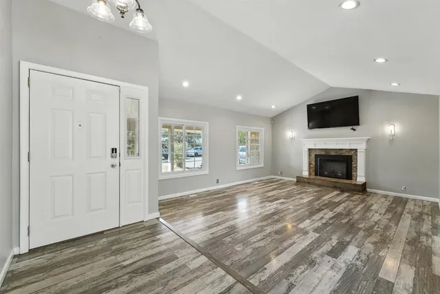 a view of empty room with fireplace and wooden floor