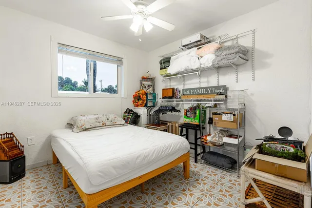 a bedroom with a bed a chandelier and dresser