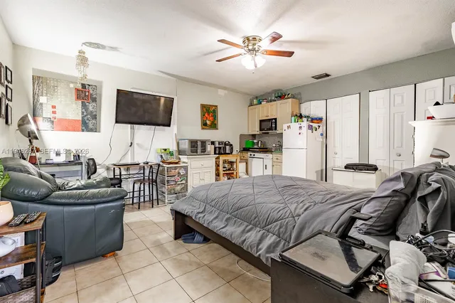 a bedroom with a bed a couch and a flat screen tv