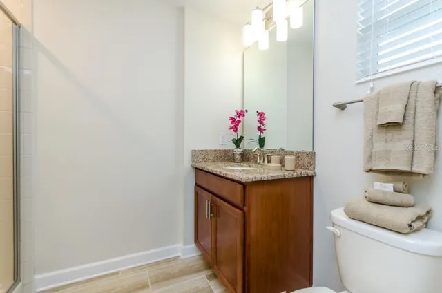 a bathroom with a granite countertop sink and a mirror