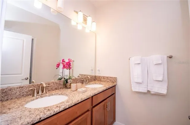 a bathroom with a granite countertop sink and a mirror