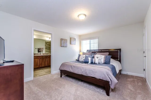 a bedroom with a bed and a view of kitchen