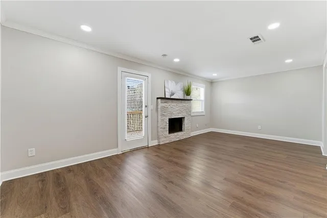 an empty room with wooden floor and fireplace