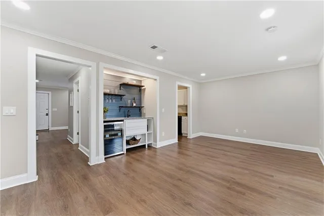 an empty room with wooden floor and a bathroom