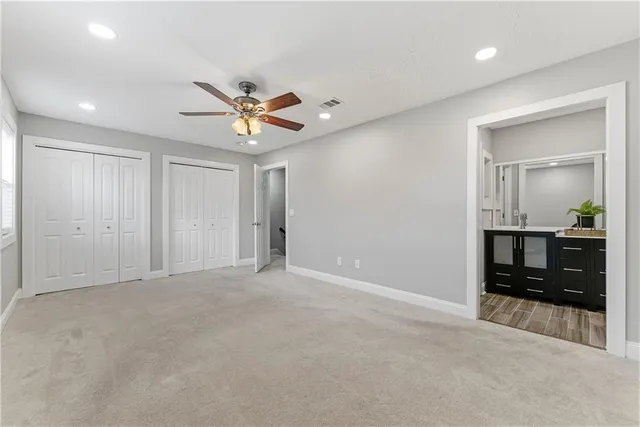 an empty room with closet and a chandelier fan