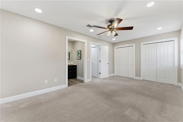 an empty room with closet and a ceiling fan