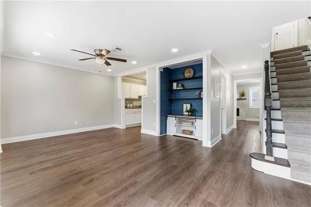 a view of a kitchen with wooden floor and a kitchen space with a sink
