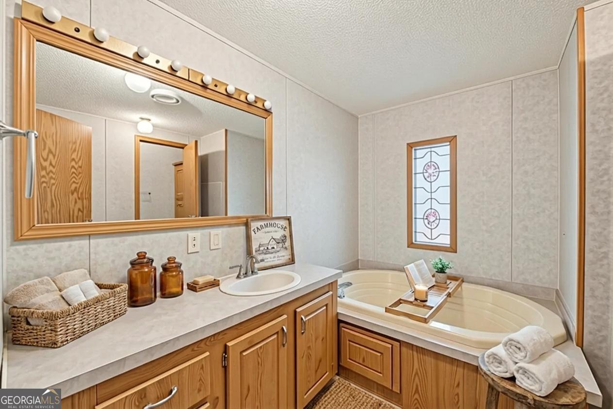 362 Horton Road Dahlonega, GA 30533 - Photo 21 of 57 a bathroom with a granite countertop sink and a mirror