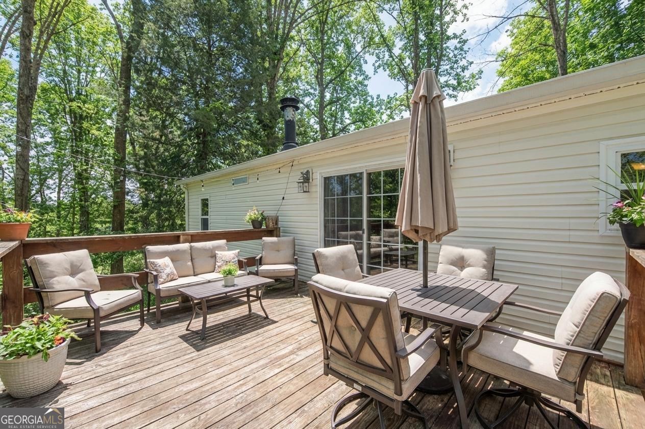 362 Horton Road Dahlonega, GA 30533 - Photo 39 of 57 a view of a patio with a dining table and chairs with wooden floor and fence