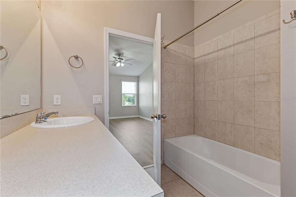 506 Rainbow Springs Loop Groveland, FL 34736 - Photo 20 of 30 a bathroom with a tub sink and mirror