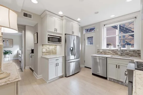 a kitchen with stainless steel appliances a refrigerator sink and stove