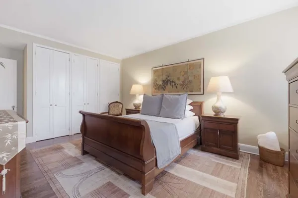 a spacious bedroom with a bed and a painting on the wall