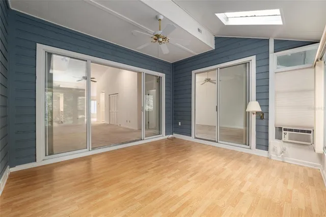 a view of empty room with wooden floor and fan