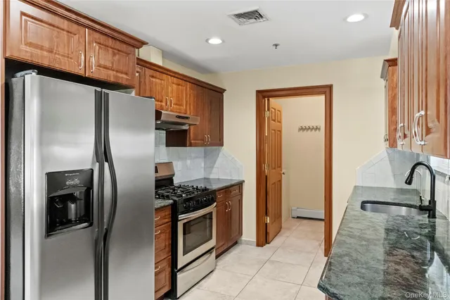 a kitchen with stainless steel appliances granite countertop a refrigerator and a sink